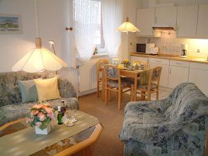 ein Wohnzimmer mit einem Sofa und einem Tisch in der Unterkunft Haus Nordstrand Berliner Strasse 1a in Büsum