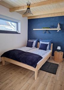 a bedroom with a large bed with blue walls at Siedlisko DoReMiDo-mki "bez barier" SPA in Dzianisz +70 photos