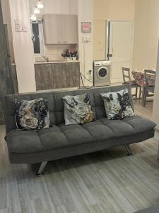 a gray couch with pillows in a living room at Near Finikoudes Beach 15 in Larnaca