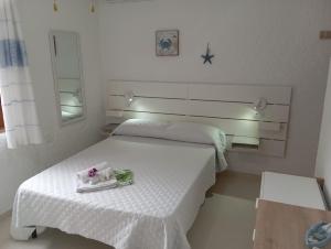 a white room with two beds and a table at B&B Rena Majore con piscina privata! in Rena Majore
