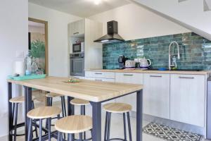 a kitchen with a table and stools in it at Dragon Fly Location saisonnier in Le Tampon