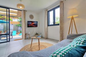 a bedroom with a bed and a table at Dragon Fly Location saisonnier in Le Tampon
