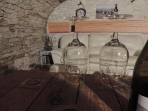 two wine glasses sitting on top of a wooden table at Auprès du Lavoir in Remigny