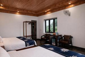 a bedroom with two beds and a desk and a window at Senna Garden Homestay in Xuân Sơn +40 photos