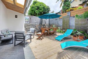 a patio with a table and chairs and an umbrella at Dragon Fly Location saisonnier in Le Tampon