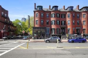 a street with cars parked in front of a building at RENU on Tremont in Boston