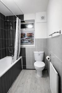 a bathroom with a toilet and a bath tub at Midnight Horizon - shared bathroom in Ponders End