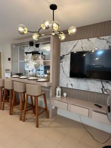 a dining room with a bar with a large tv at Executive Family Condo Unit in Iloilo City