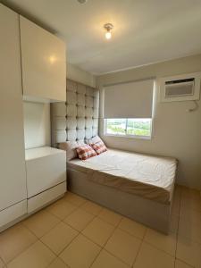 a small bedroom with a bed and a window at Executive Family Condo Unit in Iloilo City +29 photos