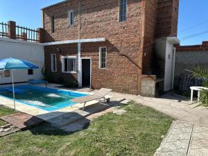 a house with a swimming pool and an umbrella at casa quinta oasis2 in Oro Verde
