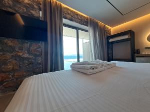 a bedroom with a bed with two towels on it at Castella Luxe in Loutro