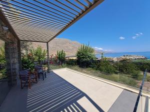 a patio with chairs and a view of the ocean at Castella Luxe in Loutro