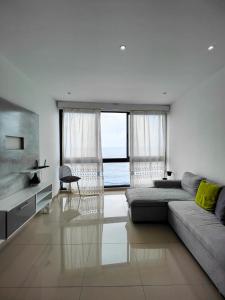 ein Wohnzimmer mit Sofa und Meerblick in der Unterkunft Casa Nova in Ribeira Grande