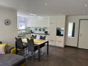 a kitchen and dining room with a table and chairs at Papillon in Saas-Grund