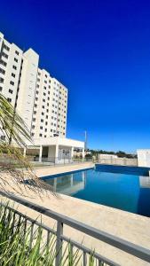 a large swimming pool in front of some buildings at Apartamento da Lagoa in Londrina