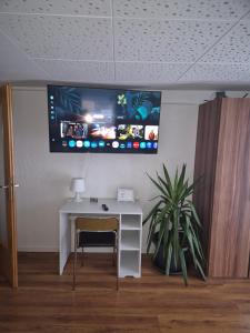 a room with a desk and a tv on the wall at Ferienwohnung Selb in Selb