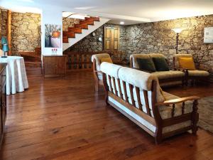 a living room with a couch and a stone wall at casa na aldeia - entre Fundão e Covilhã in Pêro Viseu
