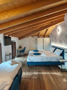 ein Schlafzimmer mit zwei Betten in einem Zimmer mit Holzdecke in der Unterkunft 4 Elementi Relais B&B Lonato del Garda in Lonato