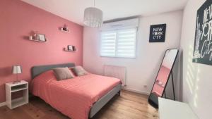 a bedroom with a bed and a pink wall at Superbe Maison avec jardin in Bezannes-les-Reims