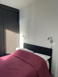 a bedroom with a bed with a red blanket at JuLieze Apartment at Sea & Pool in Ostend