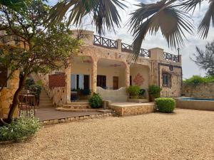 a house with a palm tree in front of it at Villa La beauté luxueuse in Rufisque