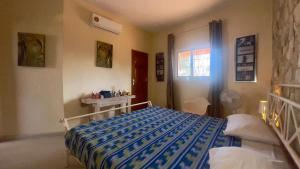 a bedroom with a bed with a blue comforter at Villa La beauté luxueuse in Rufisque +18 photos