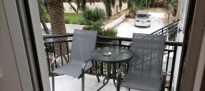 a balcony with a table and chairs and a car at Αλέξανδρος 4 in Myrina