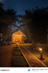 a house at night with a track in front of it at Almond Breeze Cottage in Udawalawe +7 photos