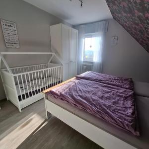 a bedroom with a crib and a purple bed at Ferienwohnung Lampe in Altenberge