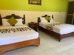 two beds in a room with green walls at Hotel Real in Chiapa de Corzo +37 photos