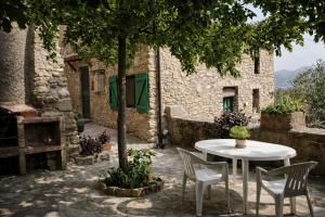 ein weißer Tisch und Stühle vor einem Gebäude in der Unterkunft Casa amb vista a les muntanyes - Cal Valeri in Montsonis