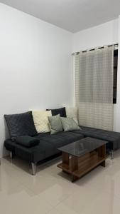 a black couch and a coffee table in a room at Aey Mabini Homestay in Mabini