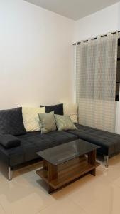 a black couch in a living room with a coffee table at Aey Mabini Homestay in Mabini