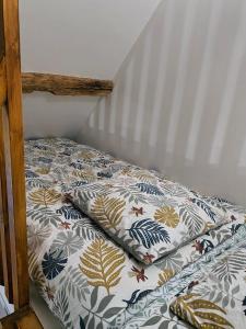a bed with a comforter on top of it at Maisons de campagne. Gîte vert. in Brigné +22 photos