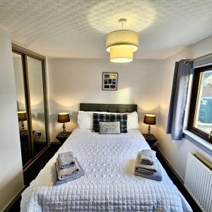 a bedroom with a large bed with towels on it at BAYVIEW in Stornoway