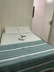 a bedroom with a bed with a hat on it at Suite in Arraial do Cabo in Arraial do Cabo