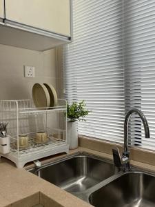 a kitchen sink with a dish rack next to a window at Leegarden Apartment-3BR in Sibu