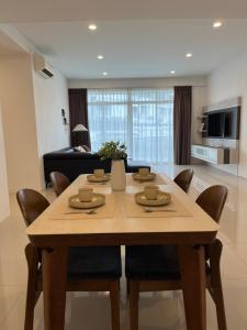a dining table and chairs in a living room at Leegarden Apartment-3BR in Sibu