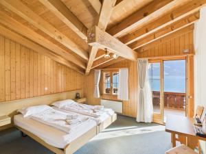 a bedroom with a bed in a room with wooden walls at Hotel Wildbach Brienz - Self Check-in in Brienz