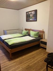 a bedroom with a bed with green pillows at Rhöner Sternenhimmel FeWo 1 und 2 in Frankenheim +52 photos