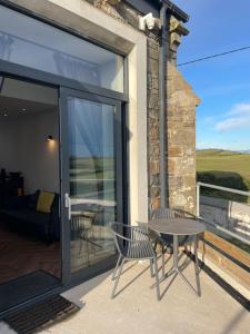 a patio with a table and a chair on a balcony at School house Portaferry in Portaferry