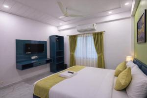 a hotel room with a bed and a tv at Hotel The Hood in Nagpur