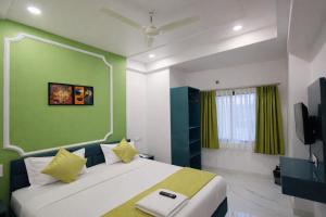 a bedroom with a bed and a green wall at Hotel The Hood in Nagpur +15 photos
