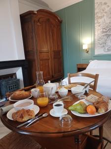 a table with breakfast foods and orange juice on it at Manoir de Salleviale in Conques-en-Rouergue +6 photos