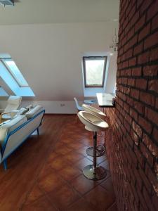 a room with chairs and a brick wall at Rooftop Apartment in Šamorín