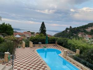 a swimming pool in the middle of a patio with a view at Villa Tzitzifies in Kouroukláta