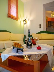 a living room with a table with a bottle of wine and glasses at Villa Tzitzifies in Kouroukláta