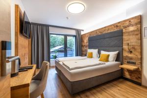 a bedroom with a bed and a desk and a television at Aparthotel Fuxbau in Flachau +68 photos