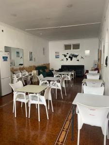 a room filled with tables and white chairs at Terraza del Limonar in Málaga