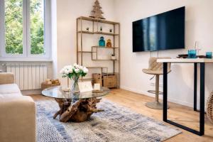 a living room with a table and a tv at Boutique Apartment Trieste in Trieste